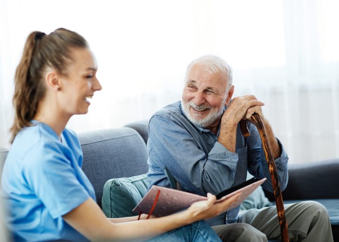 A care worker talking with an older man at home